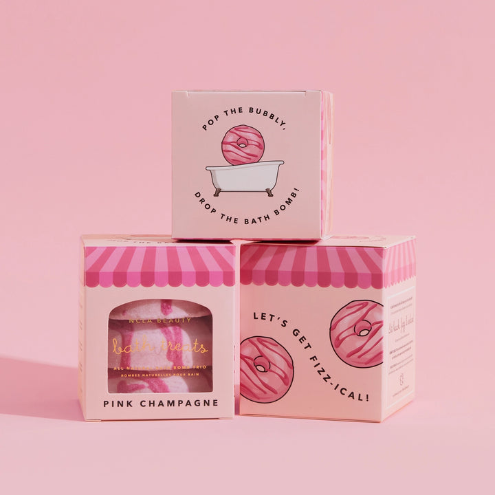 Three pink bath bomb boxes with decorative designs and text on a pink background