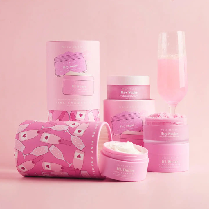 Pink skincare products with champagne bottles pattern on a pink background