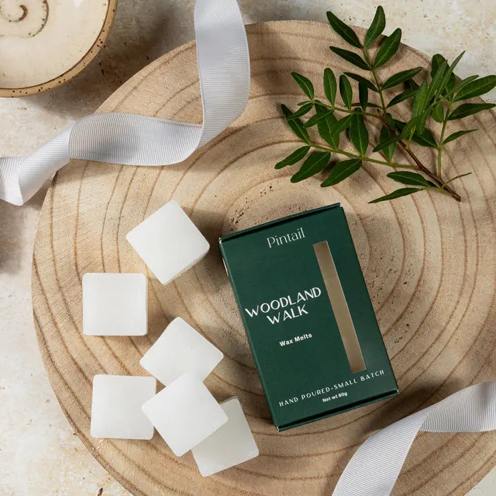 Pintail Woodland Walk wax melts packaging with wax melts and a branch on a wooden board.