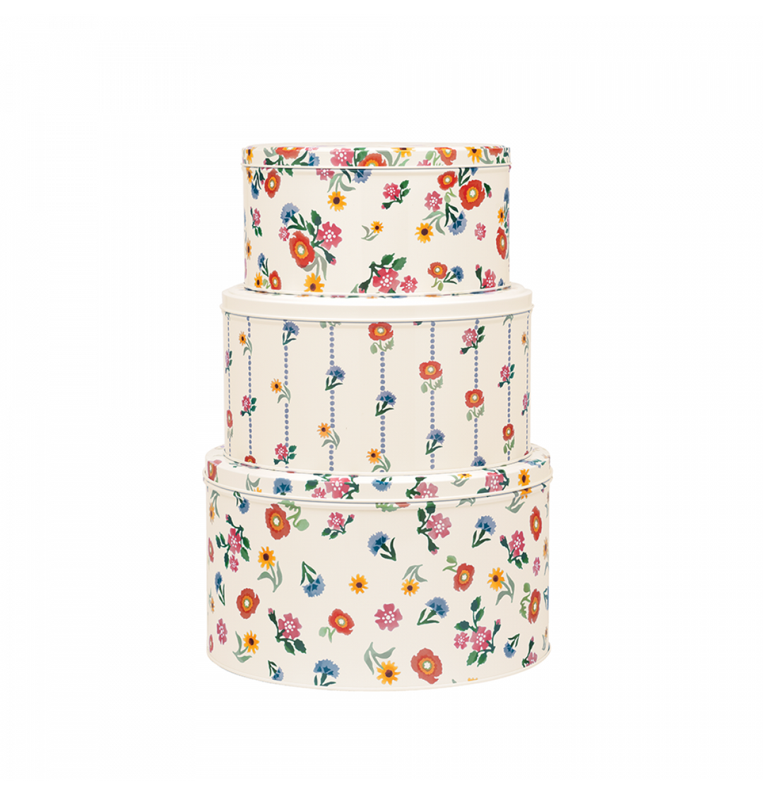 Set of three floral-patterned storage tins on a white background