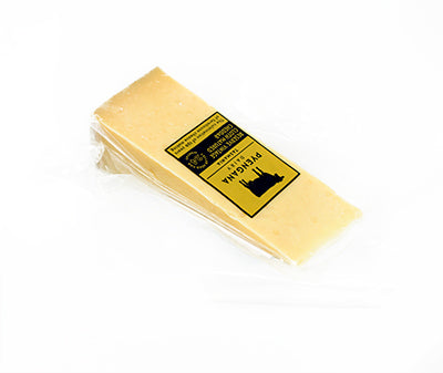 a piece of Pyengana cheddar in packaging on a white background