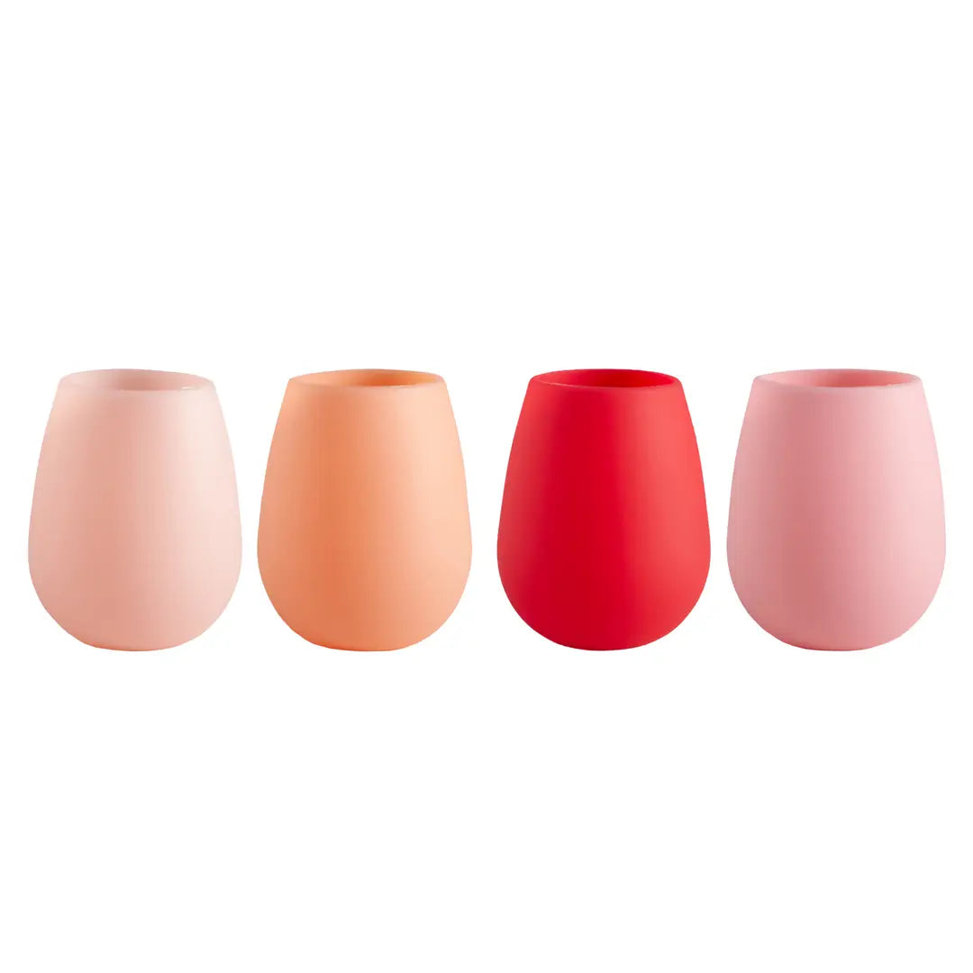 Four silicone stemless wine glasses in pastel shades of pink, orange, and red, arranged in a row against a solid white background.