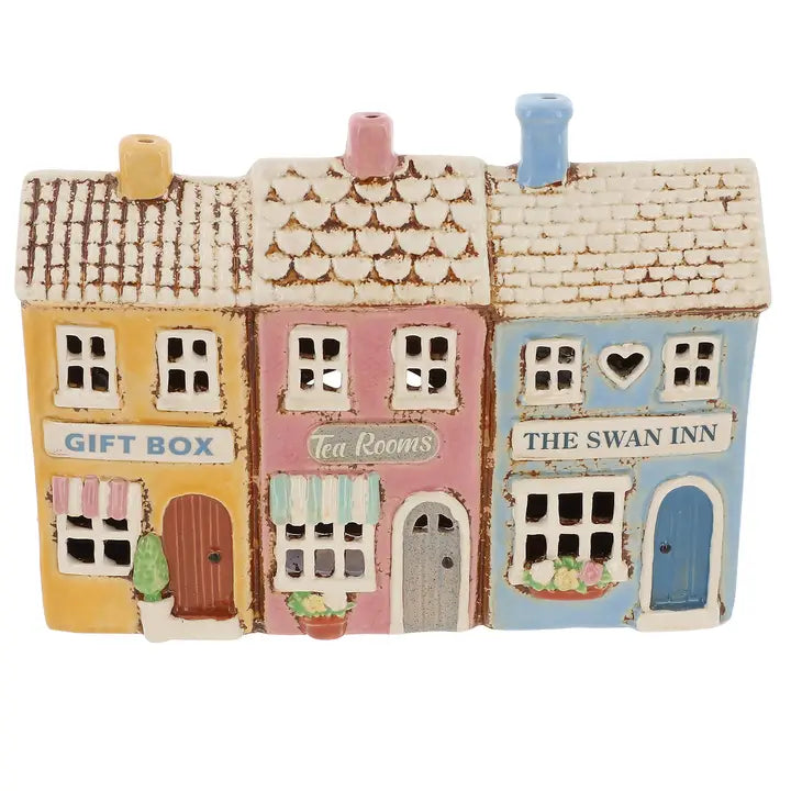 Decorative ceramic village scene with 'Gift Box', 'Tea Rooms', and 'The Swan Inn' signs on a white background.