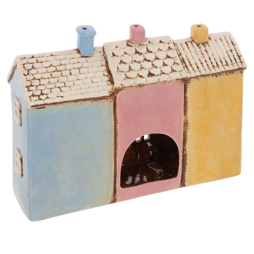 Colorful ceramic tealight holder with a textured roof on a white background