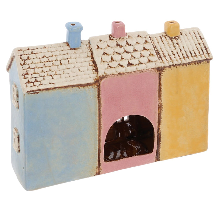 Colorful ceramic tealight holder with a textured roof on a white background