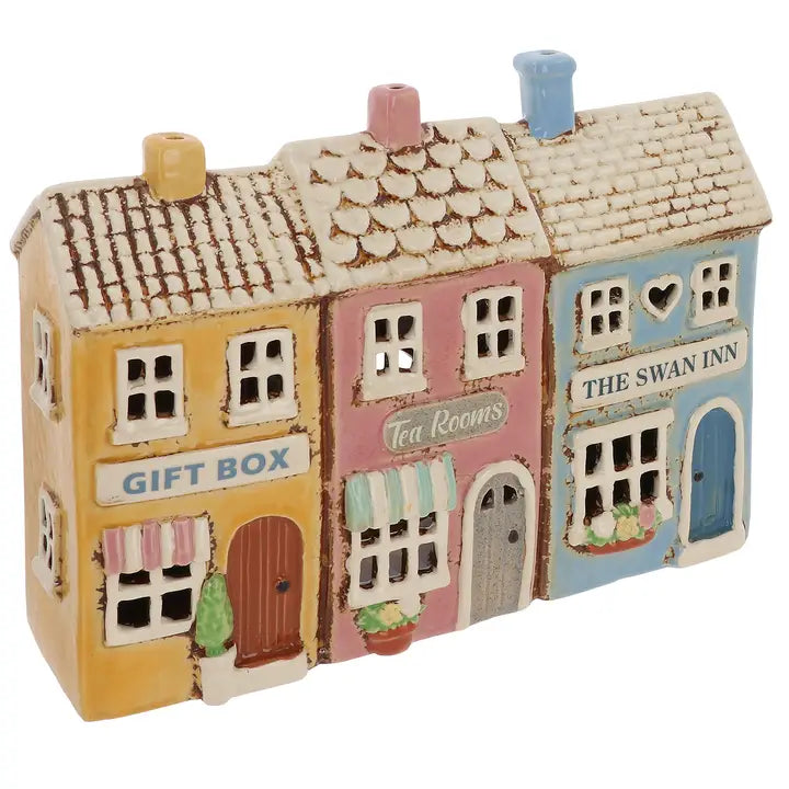 Decorative model of a small town street tealight holder with colorful buildings on a white background
