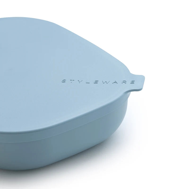 A light blue plastic container with lid with a small tab on the right side, featuring the debossed brand name &