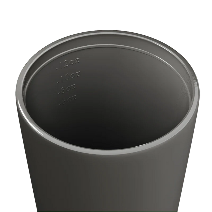 Inside of a grey travel mug with measurement markings on a white background