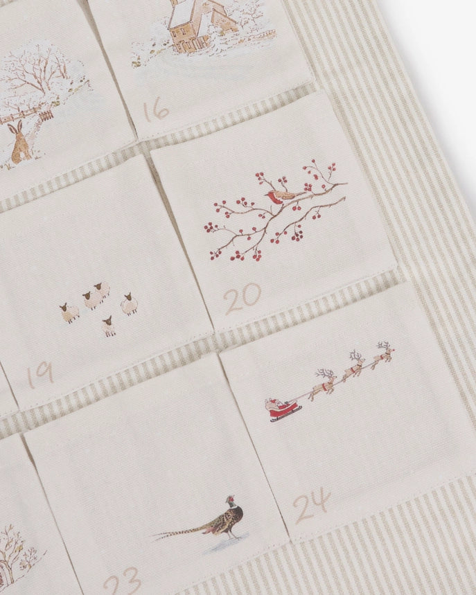 Fabric advent calendar with snowy Christmas themed designs on the pockets.