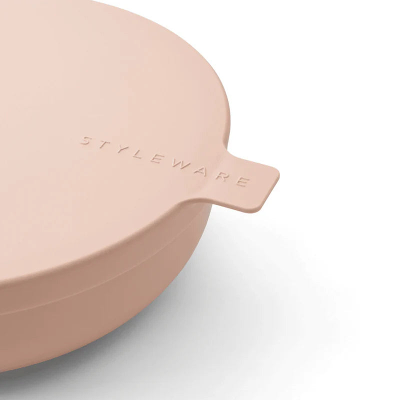 Pink storage bowl with 'STYLEWARE' branding on a light gray background