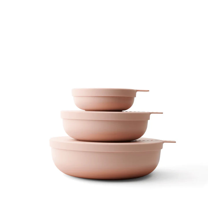 Three nested round storage bowls in a matte blush color, arranged in descending size order on a clean white background.