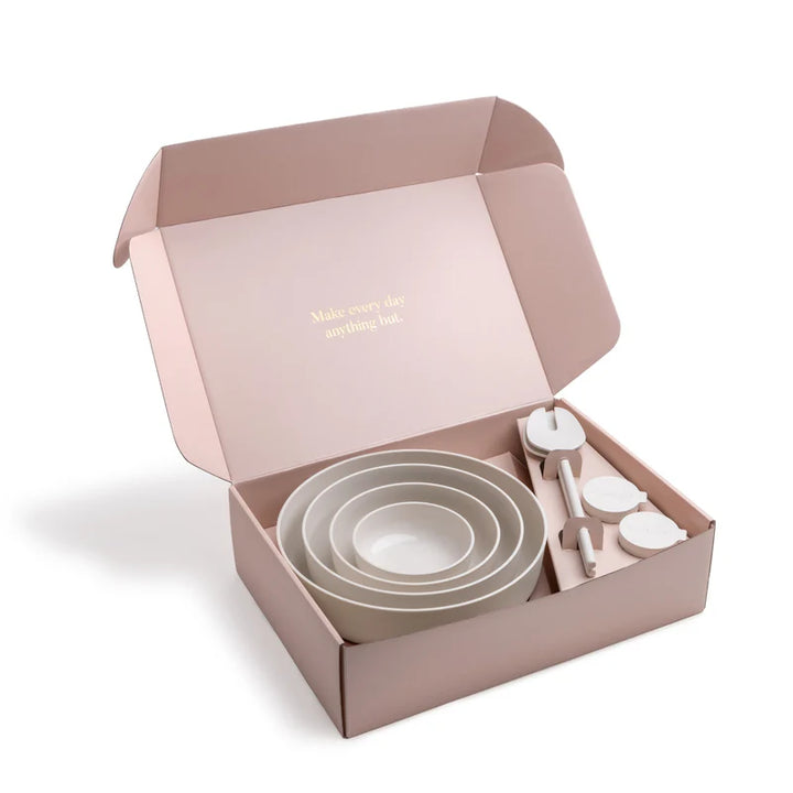 Set of plastic bowls and salad servers in a pink box with &