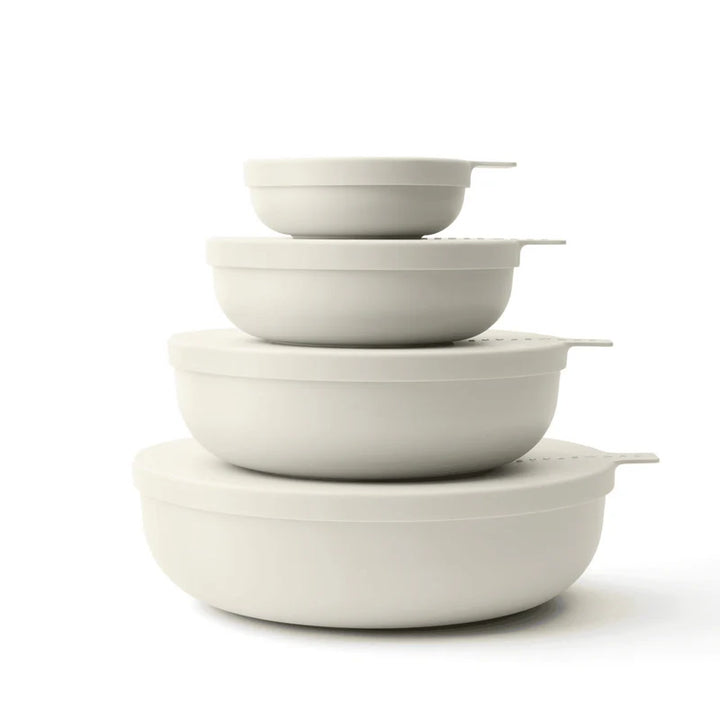 Four nested round bowls in off-white color, arranged by size with matching lids, on a clean white background.