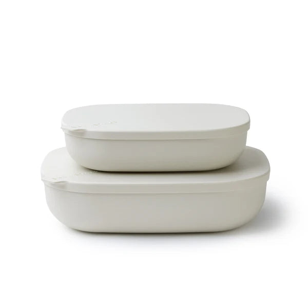 Two oval-shaped silicone lunch containers with matching lids, stacked on a clean white background.