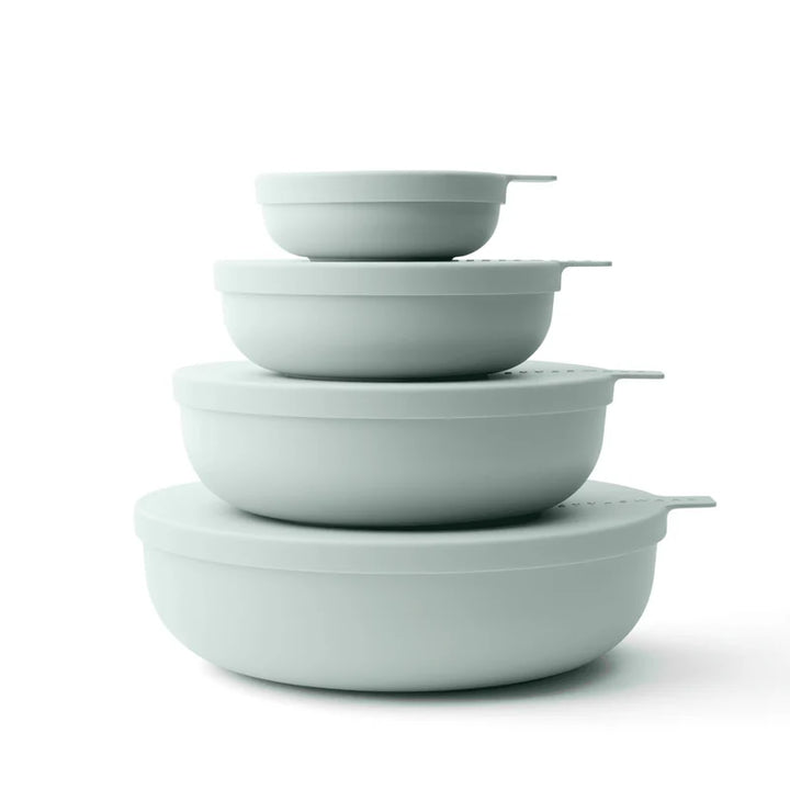 Four nested round bowls in a matte sage green color, arranged by size on a clean white background.