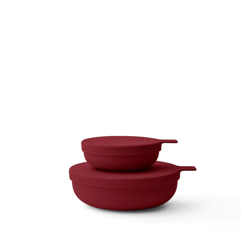 Two matte dark red food storage bowls stacked together on a clean white background.