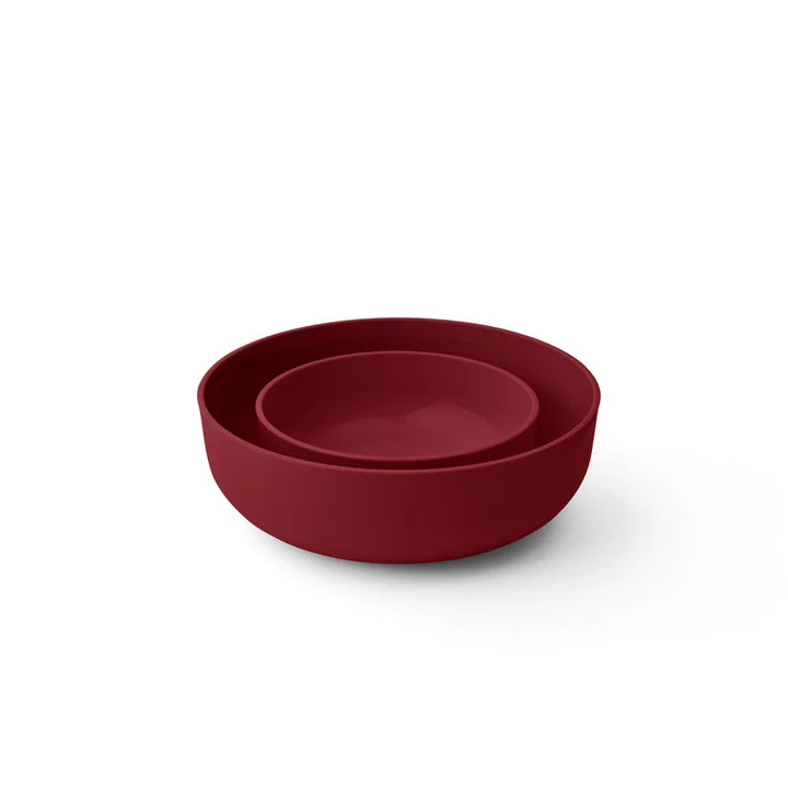 Two nested matte dark red bowls on a clean white background.