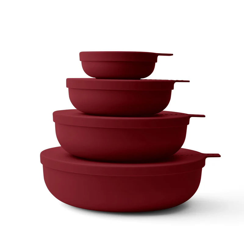 Four nested round bowls in a matte deep red color, arranged in descending size order on a clean white background.