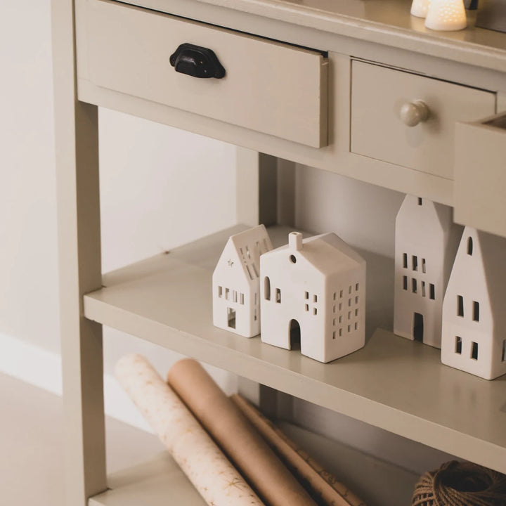 Collection of white tealight house candle holders on a hall table