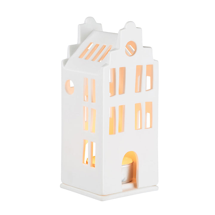 White porcelain tealight house candle holder with lit candle inside