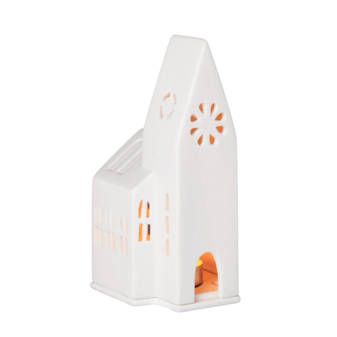 White porcelain tealight church candle holder on white background with lit candle inside