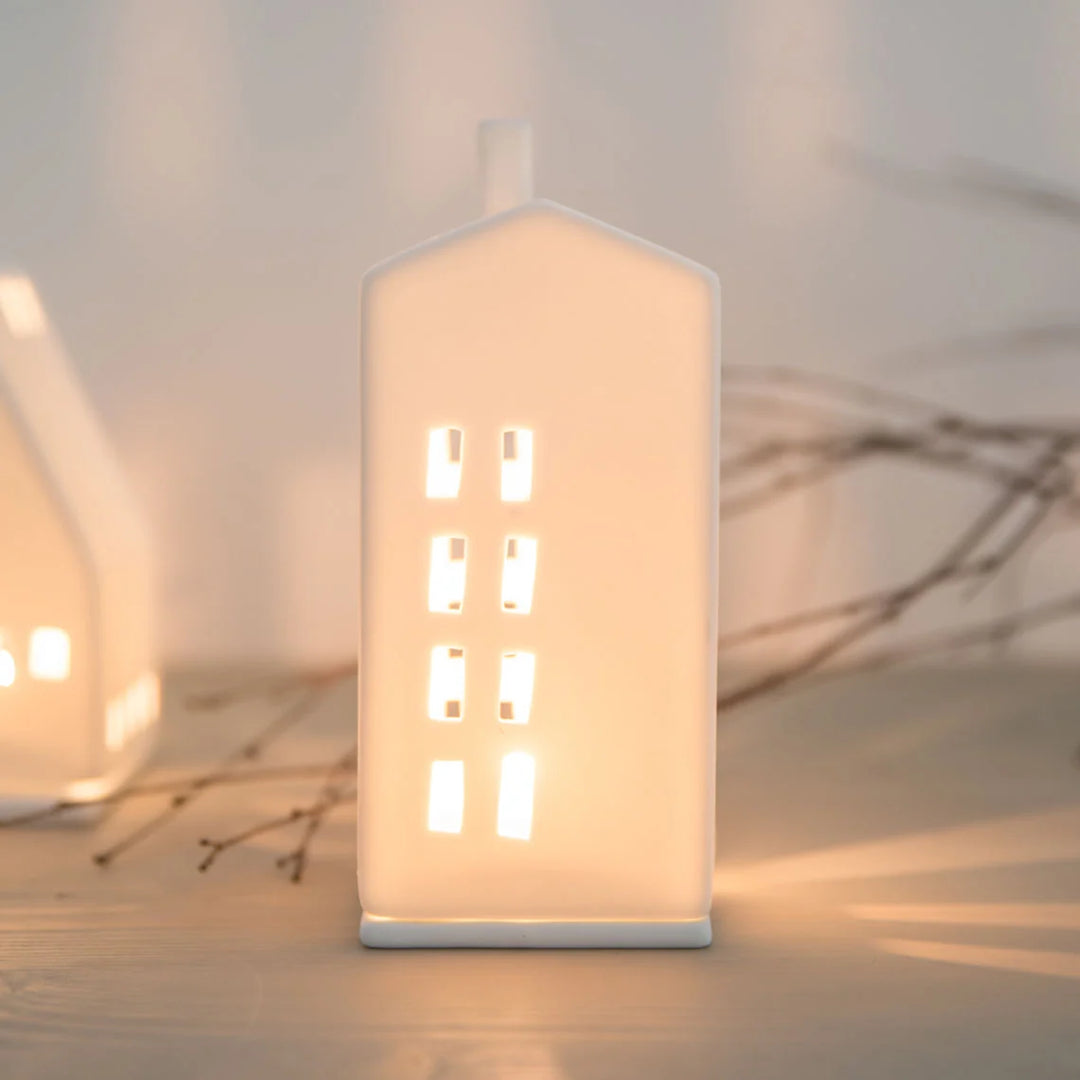 white ceramic tealight house candle holder with lit candle inside