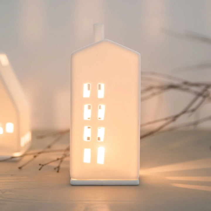 white ceramic tealight house candle holder with lit candle inside