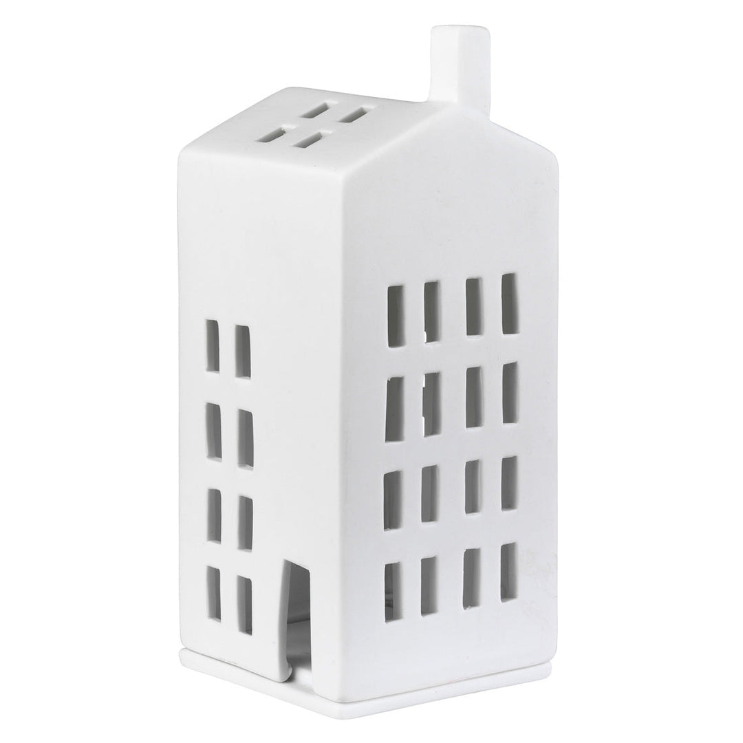 A white ceramic house-shaped candle holder with cutout windows and a small chimney, shown on a plain white background.