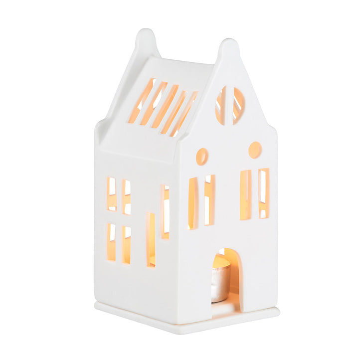 White ceramic tealight house candle holder with lit candle, on a white background