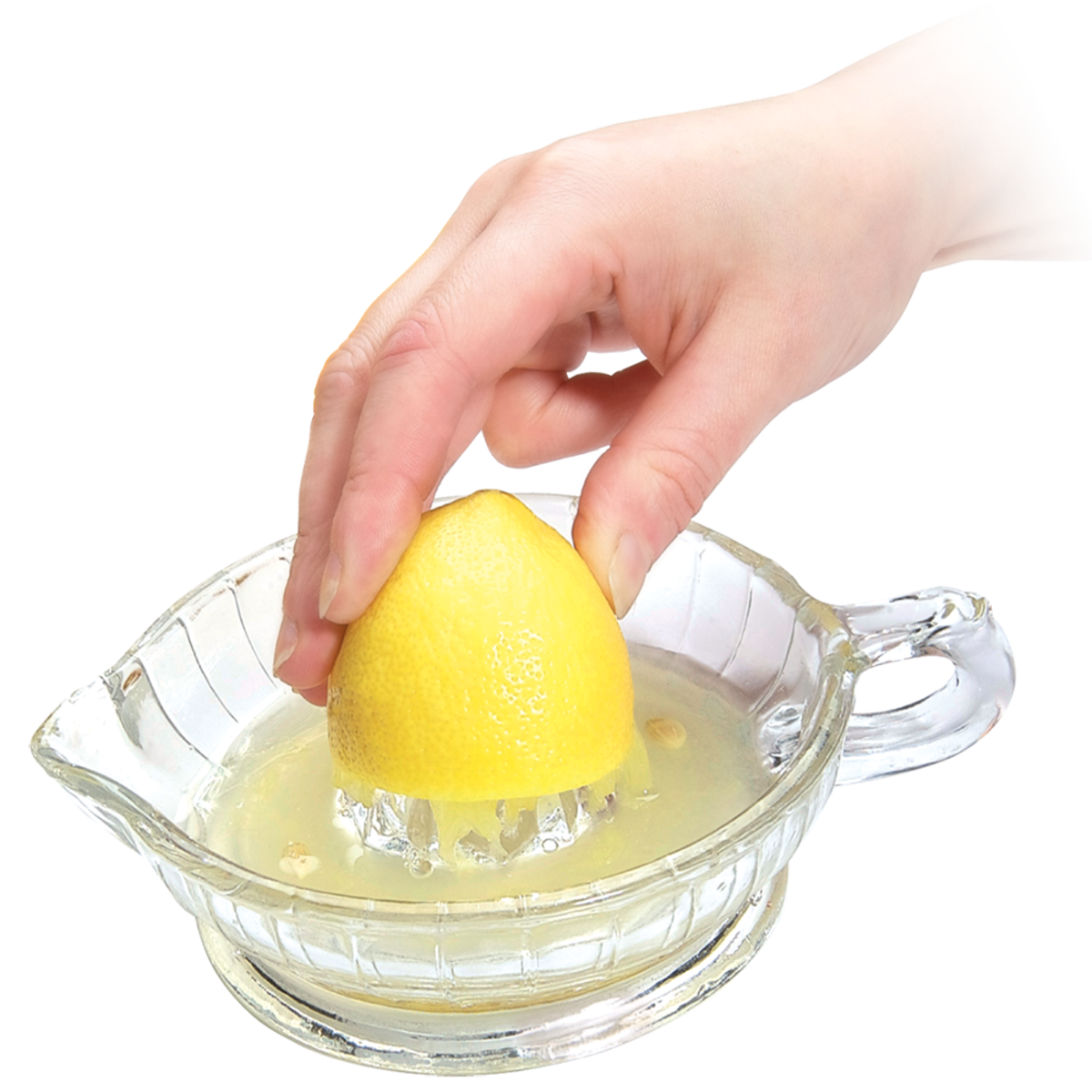 Hand using a glass lemon squeezer to extract juice from a lemon on a white background