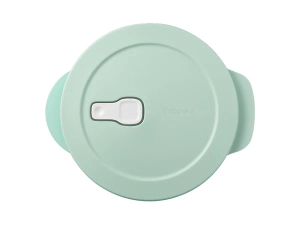 A mint green round plastic microwaveable dish with a matching lid, side handles, and a white release lever on top, isolated on a white background.