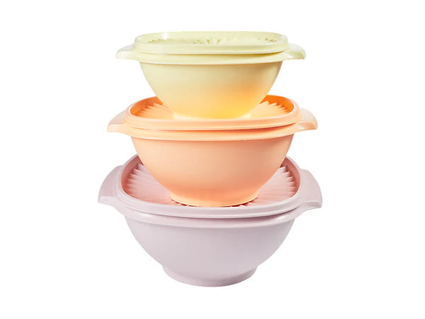 Set of three colored plastic bowls stacked on a white background