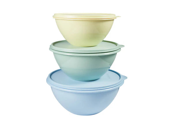 Three stacked plastic mixing bowls with matching lids in pastel shades of light blue, mint green, and pale yellow, set against a plain white background.