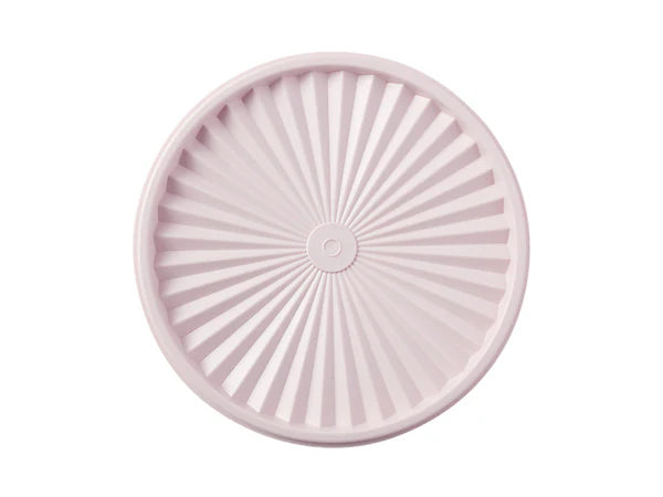 Pink silicone lid with sunburst pattern on a white background
