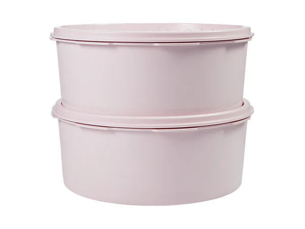 Two stacked round plastic tupperware canisters with matching lids in a very light pastel pink color, shown against a plain white background.