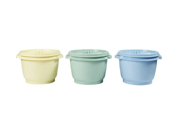 Three pastel-colored food canisters with lids on a white background