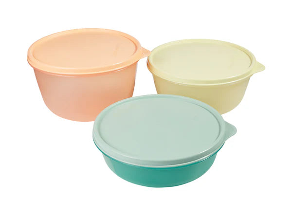 Three pastel-colored bowls with lids on a white background