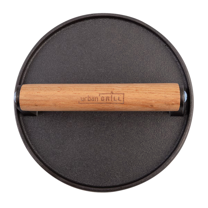 Black round grill press with wooden handle on a white background