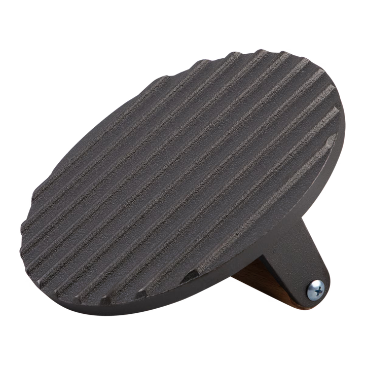 Black cast iron grill press on a white background