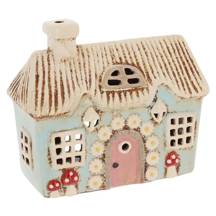 Ceramic house-shaped tealight holder with decorative elements on a white background