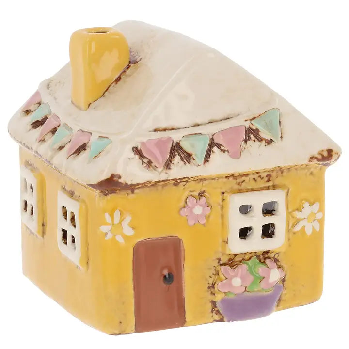 Ceramic house-shaped tealight holder with decorative elements on a white background