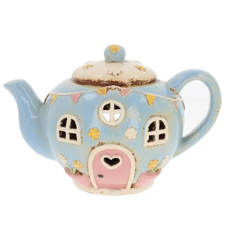 Ceramic teapot tealight holder house with a pink door and decorative elements on a white background.