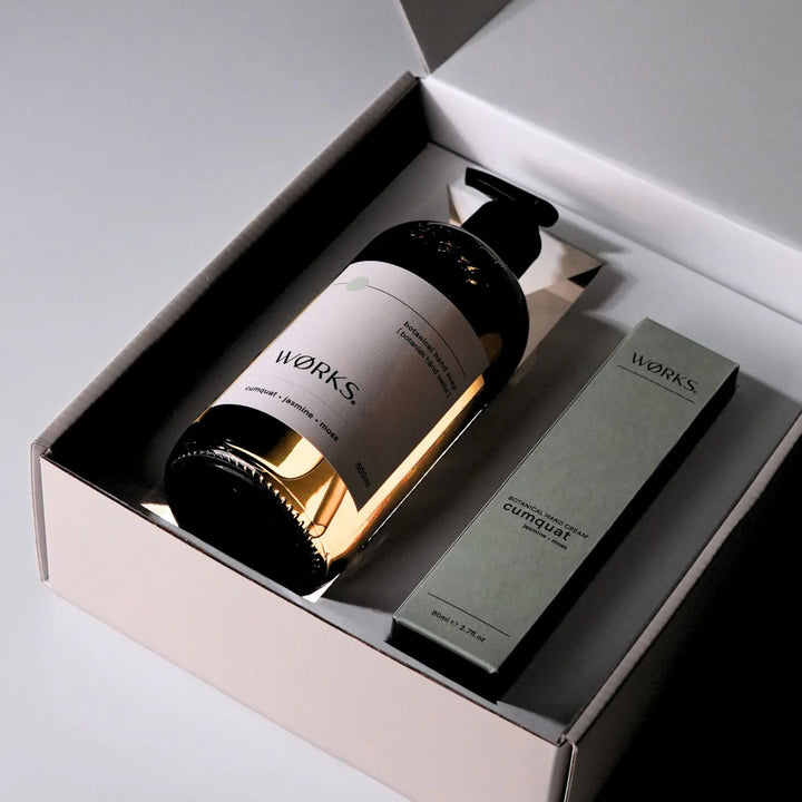 Two bottles with labels inside a box, featuring the brand &