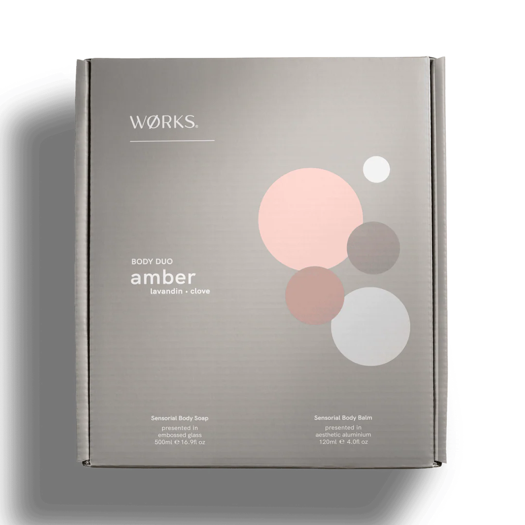 Product packaging for 'Works' body duo in amber scent on a white background