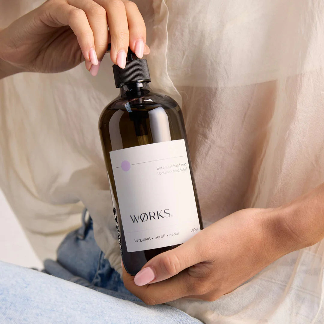 Person holding a bottle labeled &