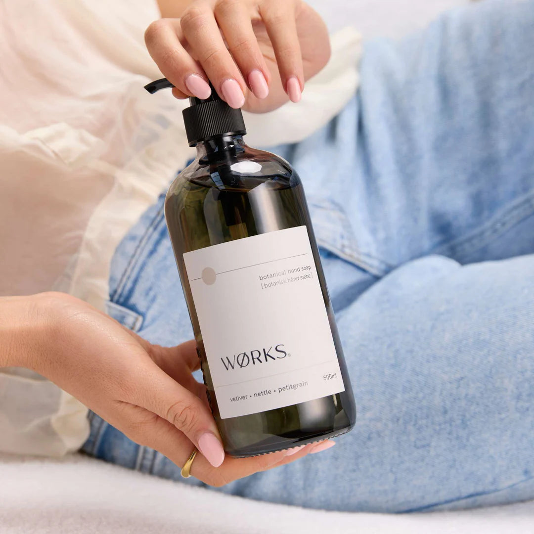 Person holding a bottle labeled 'wörks' with a neutral background