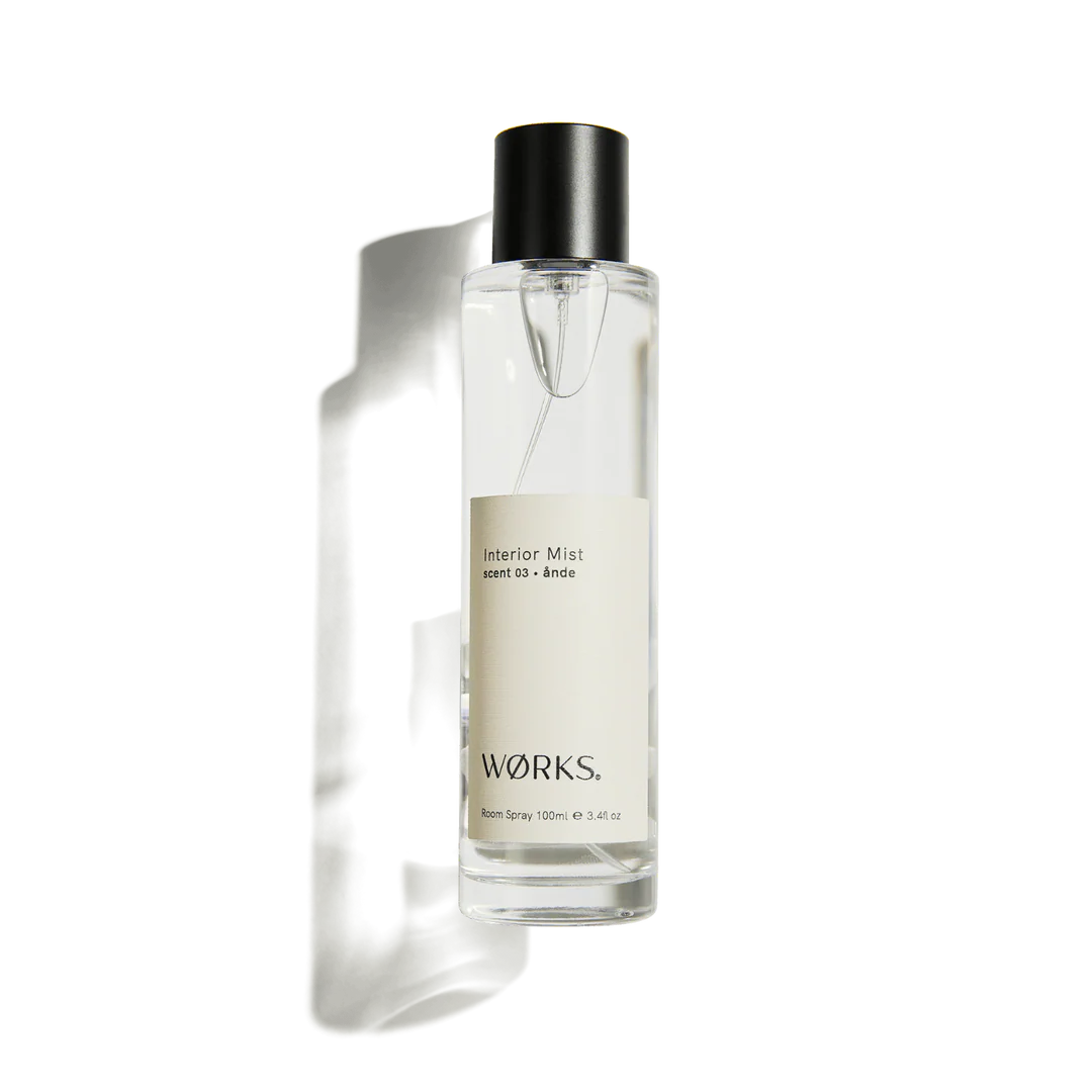 Clear spray bottle with black cap labeled 'Works' on a white background