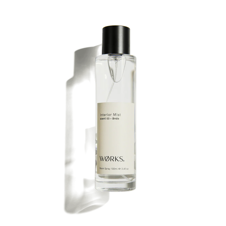 Clear spray bottle with black cap labeled &