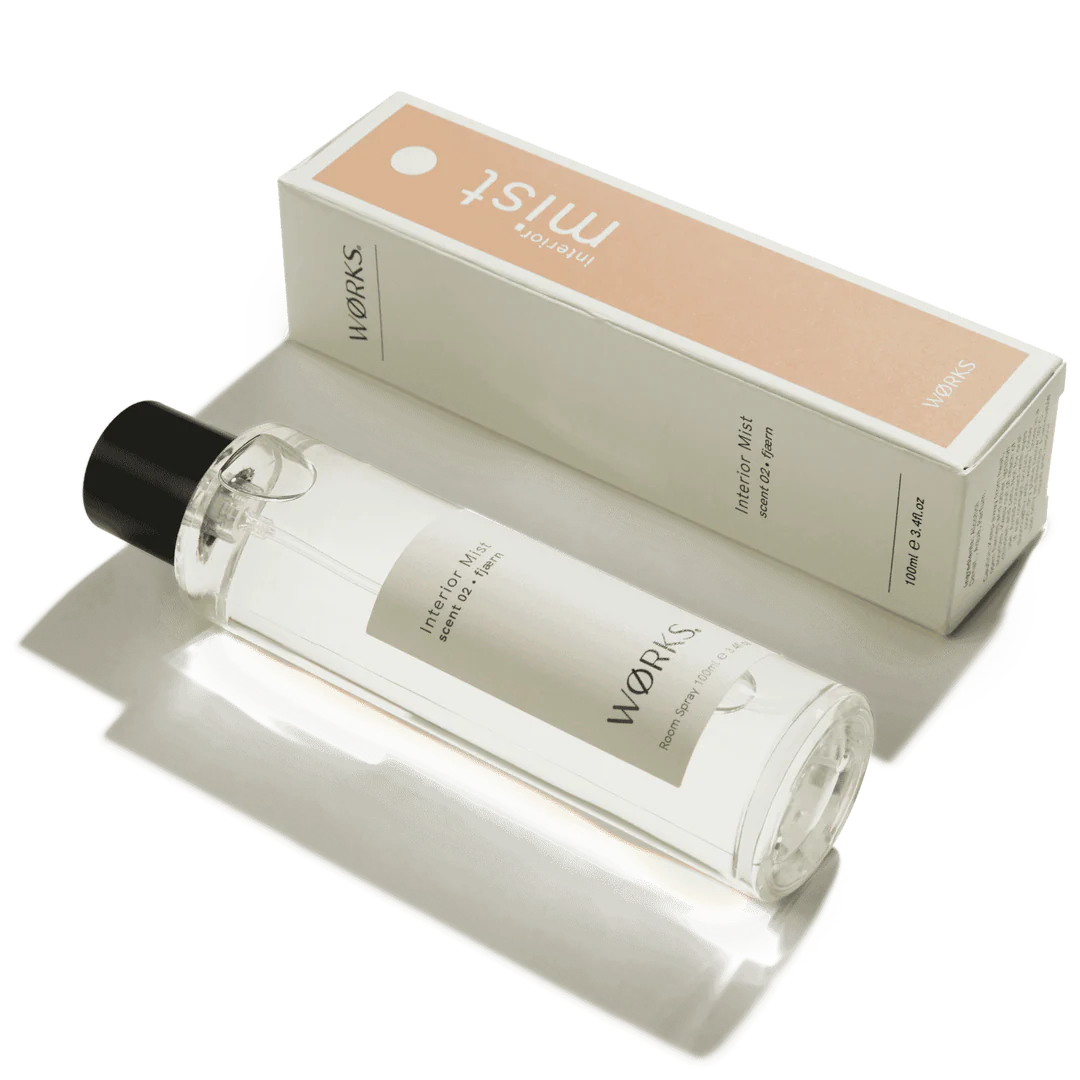 Clear bottle with black cap and beige label next to a beige box with &