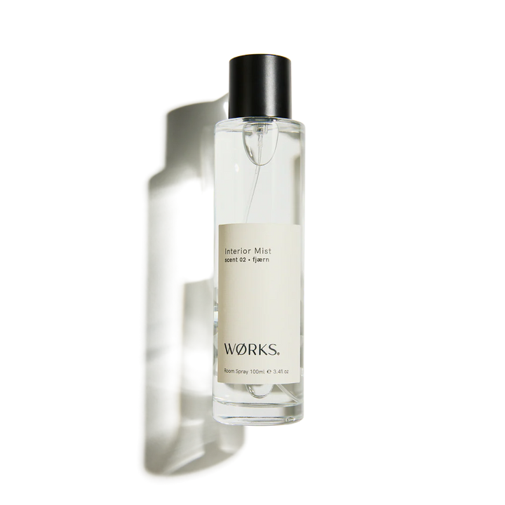 Clear spray bottle with black cap labeled &